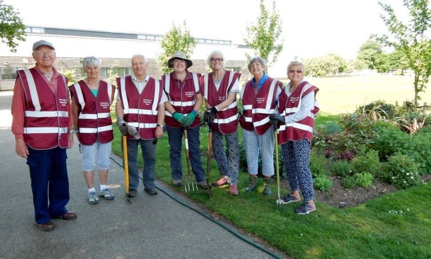 Members of the Friends of Woodford Park posing by their flower beds