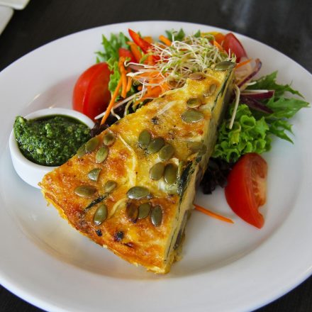 Spring quiche and salad on a white plate