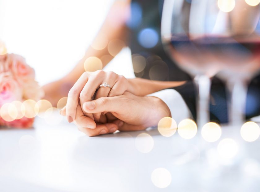 Married couple holding hands at a wedding reception table