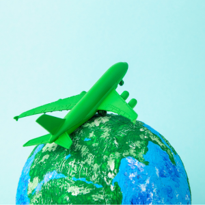 Green model plane flying around a globe