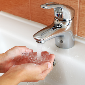 Hands being washed under a running tap